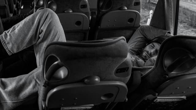 Ein Mann liegt in einem Mannschafts-Bus und schläft. Ein Mann liegt in einem Mannschafts-Bus und schläft.