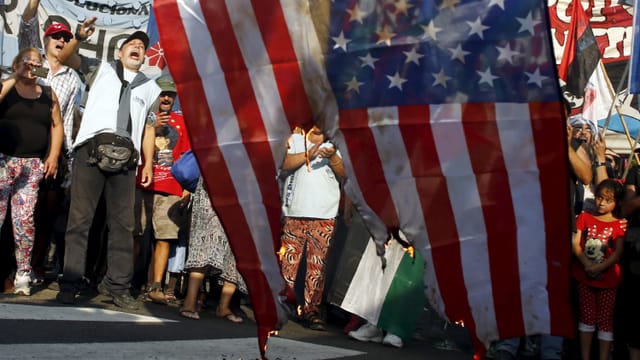 Bei Kundgebung 2015 in Caracas verbrennen Maduro-Anhänger eine US-Flagge. Bei Kundgebung 2015 in Caracas verbrennen Maduro-Anhänger eine US-Flagge.