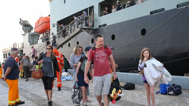 Eine evakuierte Familie verlässt das Marineschiff. Eine evakuierte Familie verlässt das Marineschiff.