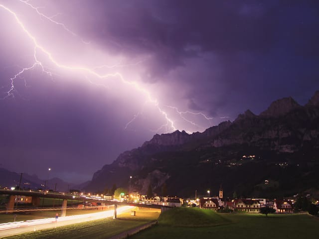 Die Bergkette der Churfirsten mit einem Blitz im Halbdunkeln
