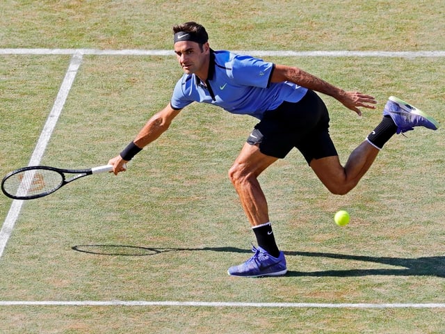 Roger Federer macht sich am Netz lang. Roger Federer macht sich am Netz lang.