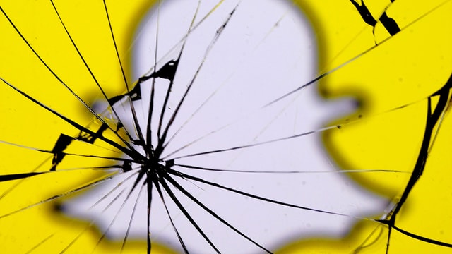 Zerprungenes Glas im Hintergrund ist das Logo von Snap-Chat Zerprungenes Glas im Hintergrund ist das Logo von Snap-Chat