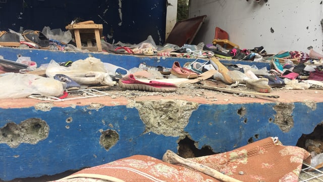 Zerschossener Laden, am Boden liegen Schuhe. Zerschossener Laden, am Boden liegen Schuhe.
