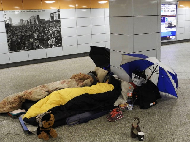 Zwei Personen in Schlafsäcken liegen in einer Unterführung. Zwei Personen in Schlafsäcken liegen in einer Unterführung.