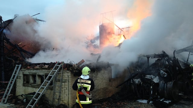 Feuerwehrmann steht vor der zerstörten Scheune. Feuerwehrmann steht vor der zerstörten Scheune.