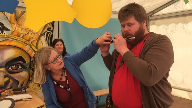 Eine Frau erklärt einem Mann, wie man in ein Piccolo blässt. Eine Frau erklärt einem Mann, wie man in ein Piccolo blässt.