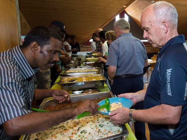 Flüchtling schöpft Maurer Essen