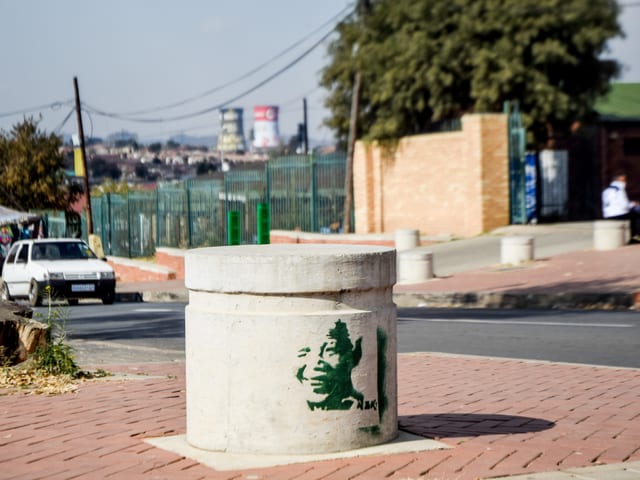 Schablonekunst, die Mandela zeigt, an einem Poller. Schablonekunst, die Mandela zeigt, an einem Poller.