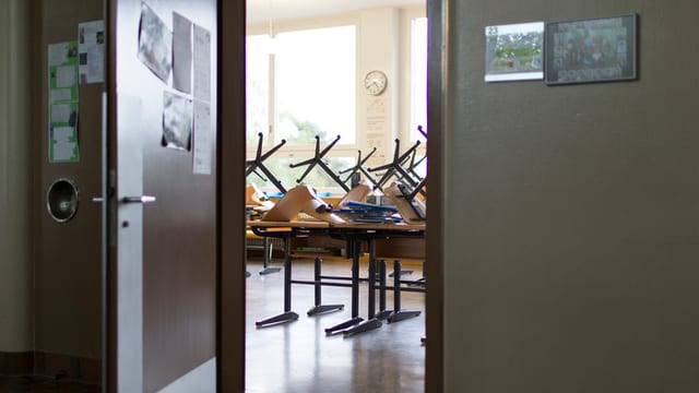 Leeres Schulzimmer mit Stühlen auf den Pulten Leeres Schulzimmer mit Stühlen auf den Pulten