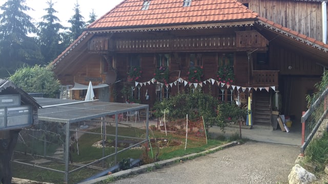 Blick auf den Tierhof - ein altes Bauernhaus mit Kleintierkäfigen davor Blick auf den Tierhof - ein altes Bauernhaus mit Kleintierkäfigen davor