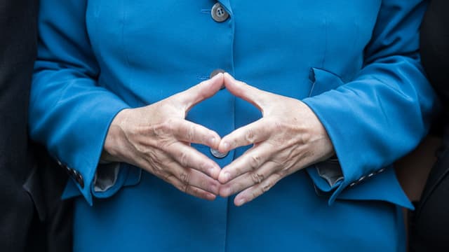 Angela Merkel ha furmà ils mauns dtar in rombus. Angela Merkel ha furmà ils mauns dtar in rombus.