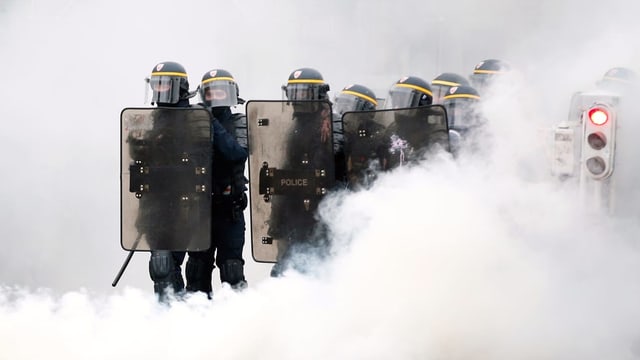 Polizei im Tränengasnebel. Polizei im Tränengasnebel.