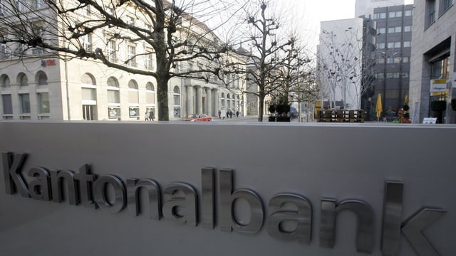 Logo der Kantonalbank, im Hintergrund die Aarauer Bahnhofstrasse mit dem alten UBS-Gebäude. Logo der Kantonalbank, im Hintergrund die Aarauer Bahnhofstrasse mit dem alten UBS-Gebäude.
