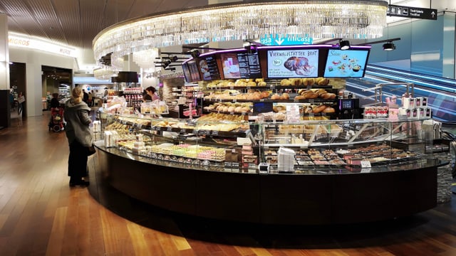 Eine Bäckerei: eine Person steht vor dem Verkaufstresen. Eine Bäckerei: eine Person steht vor dem Verkaufstresen.