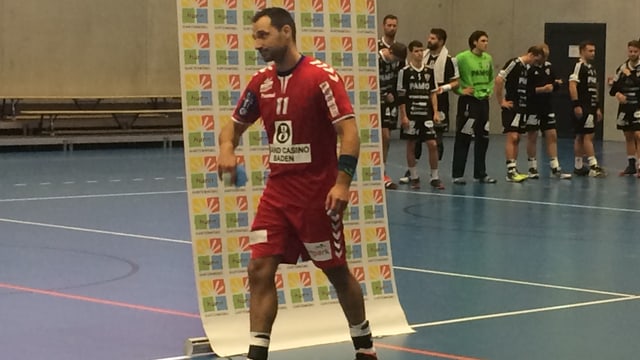 Ein Spieler läuft vor einem Plakat hindurch Ein Spieler läuft vor einem Plakat hindurch