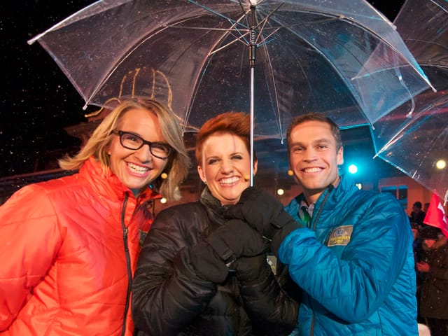 Sonja Hasler, Steffi Buchli und Renzo Blumenthal unter dem Regenschirm.