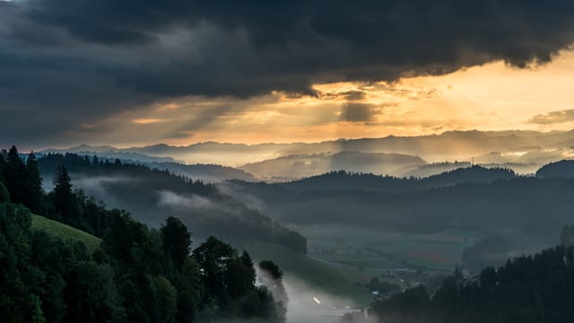 Nebel im Tal, darüber Sonnenstrahlen