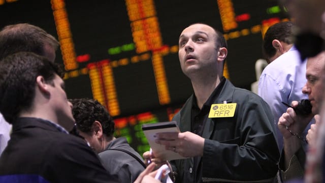 Ein Händler an der New Yorker Rohstoffbörse mit einem gelben Badge am schwarzen Jackett. Ein Händler an der New Yorker Rohstoffbörse mit einem gelben Badge am schwarzen Jackett.