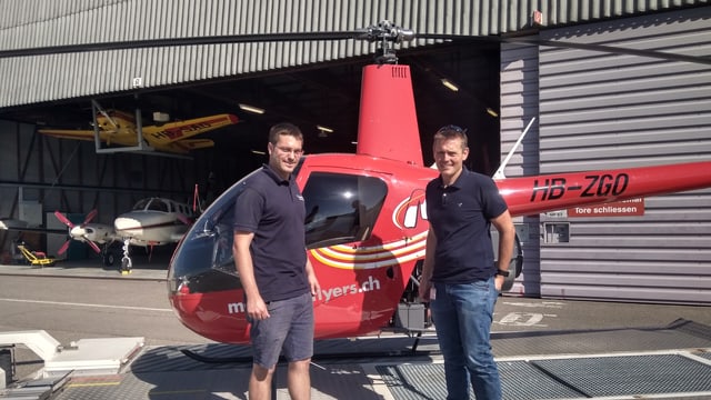 Zwei Männer vor einem Helikopter Zwei Männer vor einem Helikopter