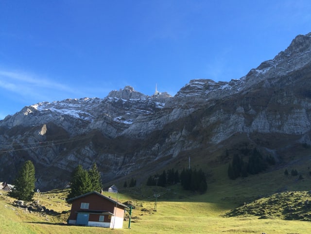 Im Vordergrund eine Liftstation, dahinter die Tragseile die zur Bergstion auf den Säntis führen. Am Gipfel ein Sendemast, darüber der blaue Himmel. Im Vordergrund eine Liftstation, dahinter die Tragseile die zur Bergstion auf den Säntis führen. Am Gipfel ein Sendemast, darüber der blaue Himmel.