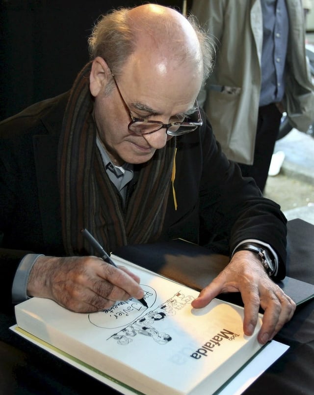 Älterer Herr signiert ein Comicbuch. Älterer Herr signiert ein Comicbuch.