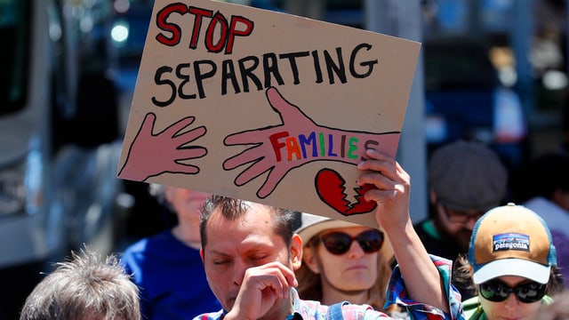 Demonstrat, der ein Plakat hochhält. Darauf steht: «Stop Separating Families» Demonstrat, der ein Plakat hochhält. Darauf steht: «Stop Separating Families»