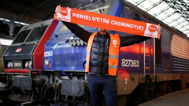 Ein Bahn-Angestellt hält ein Banner in die Luft, darauf steht: «Stolz, Eisenbahner zu sein.» (reuters) Ein Bahn-Angestellt hält ein Banner in die Luft, darauf steht: «Stolz, Eisenbahner zu sein.» (reuters)