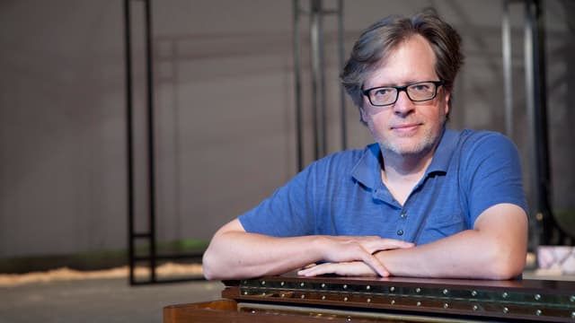 Caspar Dechmann stützt sich auf ein Klavier. Caspar Dechmann stützt sich auf ein Klavier.
