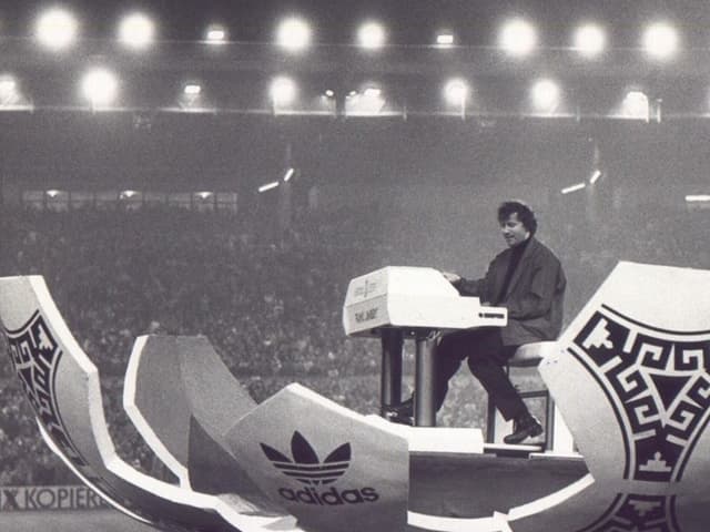 Mann spielt Hammond Orgel in aufgeklappter-Fussball-kulisse Mann spielt Hammond Orgel in aufgeklappter-Fussball-kulisse