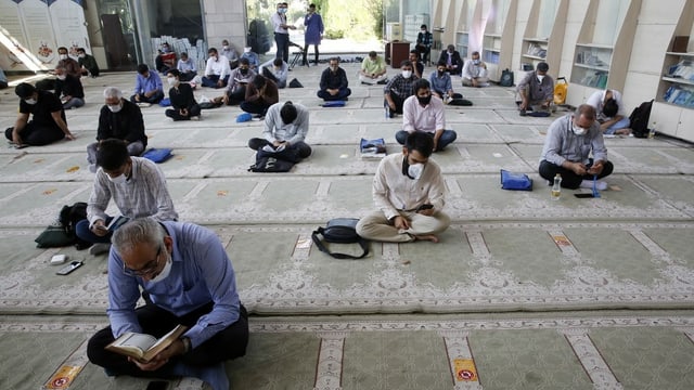Gläubige im Iran tragen beim Beten eine Maske. Gläubige im Iran tragen beim Beten eine Maske.