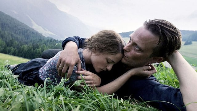Ein Mann und eine Frau liegen in der Wiese und umarmen sich. Ein Mann und eine Frau liegen in der Wiese und umarmen sich.