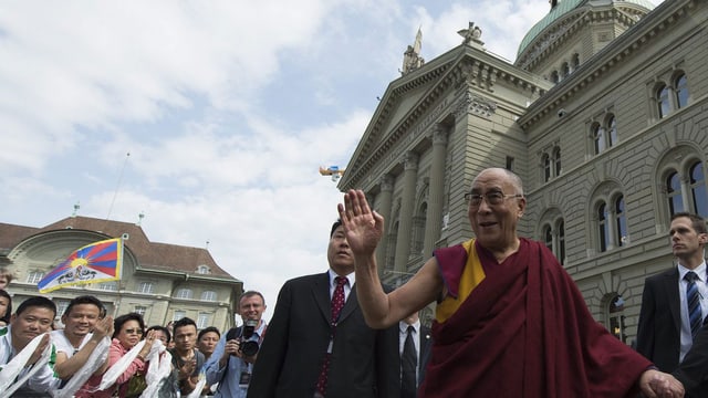 Der dalai Lama winkt der jubelnden Menge vor dem Bundeshaus zu. (keystone) Der dalai Lama winkt der jubelnden Menge vor dem Bundeshaus zu. (keystone)