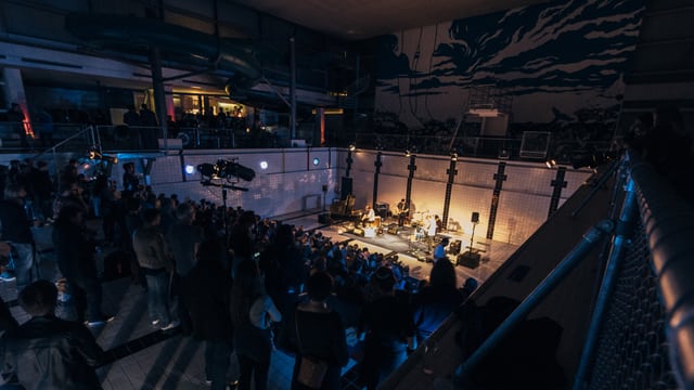 Band mit Publikum. Band spielt in einem ehemaligen Hallenband mit weissen Kacheln. Band mit Publikum. Band spielt in einem ehemaligen Hallenband mit weissen Kacheln.