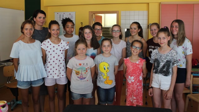Mädchen stehen in einem Schulzimmer und sehen in die Kamera. Mädchen stehen in einem Schulzimmer und sehen in die Kamera.