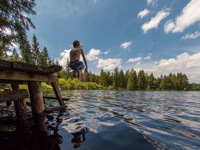 Junge springt in einen See
