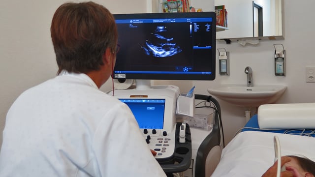 Ärztin untersucht mit Ultraschall ein Kleinkind Ärztin untersucht mit Ultraschall ein Kleinkind