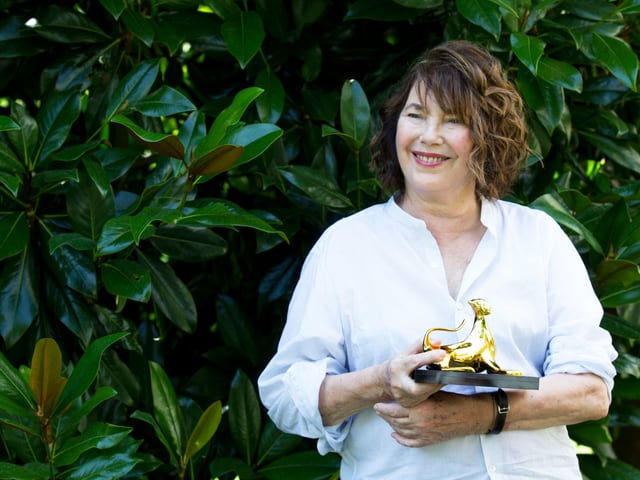 Jane Birkin hält eine goldene Leopardenstatue. Jane Birkin hält eine goldene Leopardenstatue.