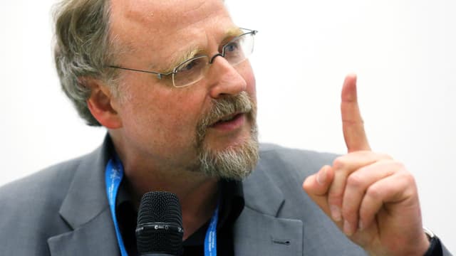 Ein Mann mit Brille hebt den Zeigfinger. Ein Mann mit Brille hebt den Zeigfinger.