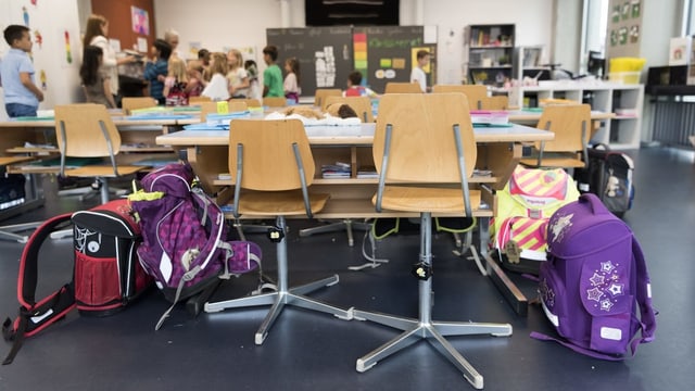 Zwei leere Plätze mit Schülern im Hintergrund Zwei leere Plätze mit Schülern im Hintergrund