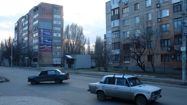 Strasse mit zwei Autos. im Hintergrund Wohnblöcke. Strasse mit zwei Autos. im Hintergrund Wohnblöcke.