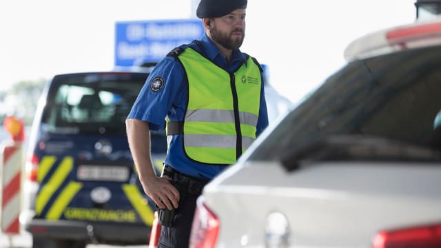 Beamter der Grenzwache kontrolliert ein Fahrzeug Beamter der Grenzwache kontrolliert ein Fahrzeug