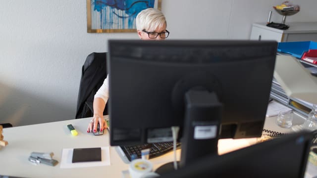 Frau an einem Computer in einem Büro Frau an einem Computer in einem Büro