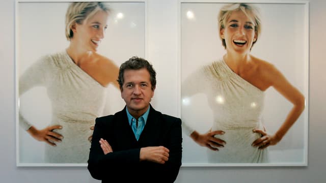 Ein Mann steht vor zwei Aufnahmen von Prinzessin Diana. Ein Mann steht vor zwei Aufnahmen von Prinzessin Diana.