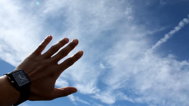 Eine Hand vor Wolken gehalten Eine Hand vor Wolken gehalten