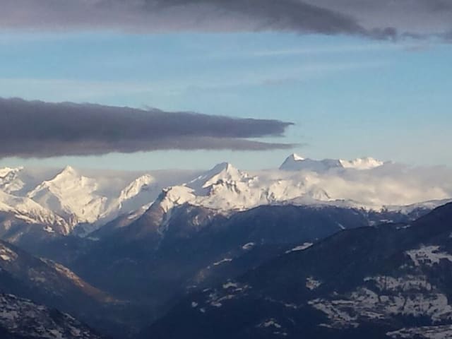 Bergpanorama im Wallis mit Matterhorn, darüber blauer Himmel mit Wolkenfeldern.