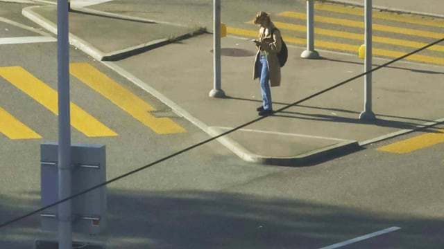 Strassenkreuzung, an der eine junge Frau alleine steht. Strassenkreuzung, an der eine junge Frau alleine steht.