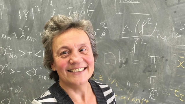 Eine Frau steht vor einer Wandtafel. Eine Frau steht vor einer Wandtafel.