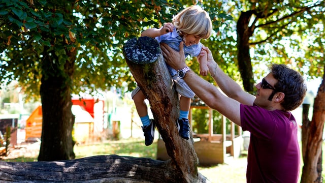 Ein Vater hilft seinem Sohn bei Klettern. Ein Vater hilft seinem Sohn bei Klettern.