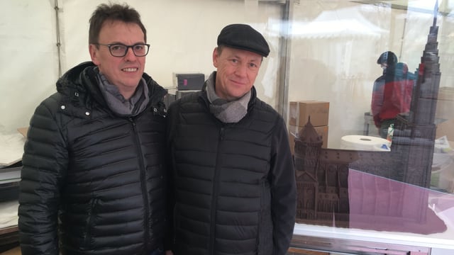Zwei Männer mit schwarzen Jacken und Schokoladenhaus Zwei Männer mit schwarzen Jacken und Schokoladenhaus
