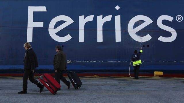 Passagiere vor einer Fähre im Hafen. Passagiere vor einer Fähre im Hafen.